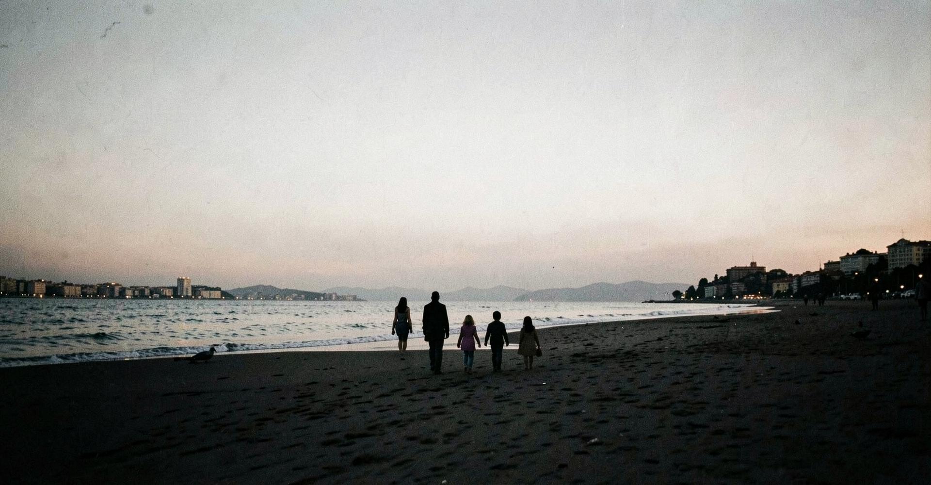 Família a caminhar ao entardecer numa praia perto de Lisboa