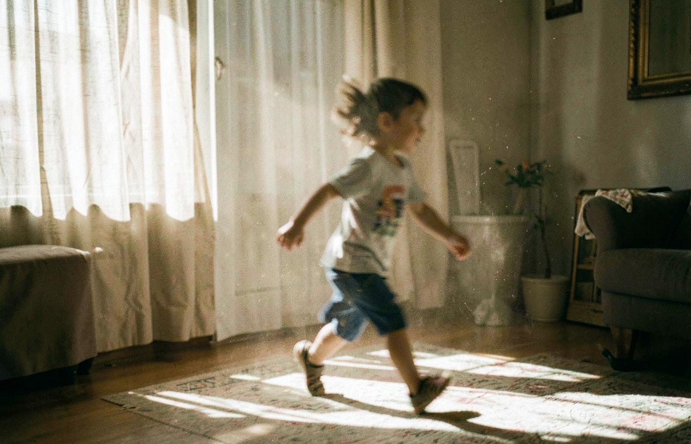 Criança a correr na luz do sol